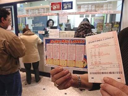 Un apostante muestra los boletos del nuevo Euromillones en una administración de lotería.