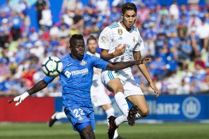 El delantero senegalés del Getafe Amath Ndiaye (i) disputa el balón con el lateral derecho del Real Madrid Achraf Hakimi.