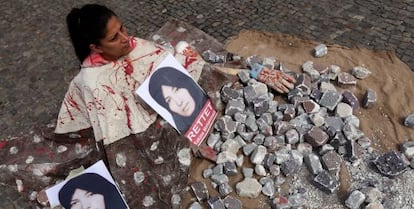 Una manifestante representa una lapidación en una protesta en Berlín.