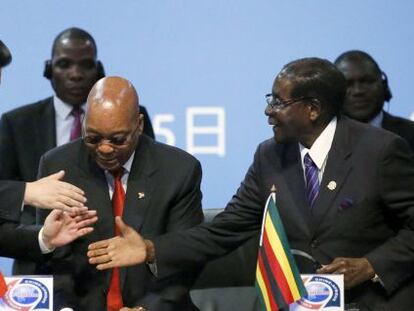 El presidente chino Xi saluda a sus homólogos zimbabuense Robert Mugabe y sudafricano Jacob Zuma en la cumbre de Johanesburgo.