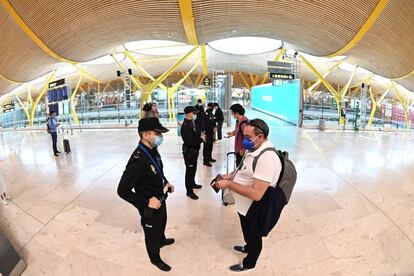 Agentes de la Polica Nacional controlan el acceso a la T-4 del Aeropuerto Adolfo Surez Madrid-Barajas, para vigilar el cumplimiento de las restricciones a la movilidad impuestas por el estado de alarma que ha decretado el Gobierno.