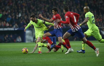 El delantero argentino del Barcelona Lionel Messi intenta escapar de varios jugadores atléticos.