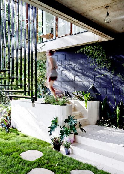 La mayoría de las plantas se escogieron para mezclarse con el bosque. Las escaleras de acero negro y madera son obra del arquitecto.