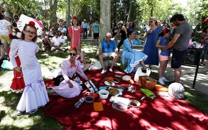 Una familia se dispone a comer en la pradera de San Isidro.