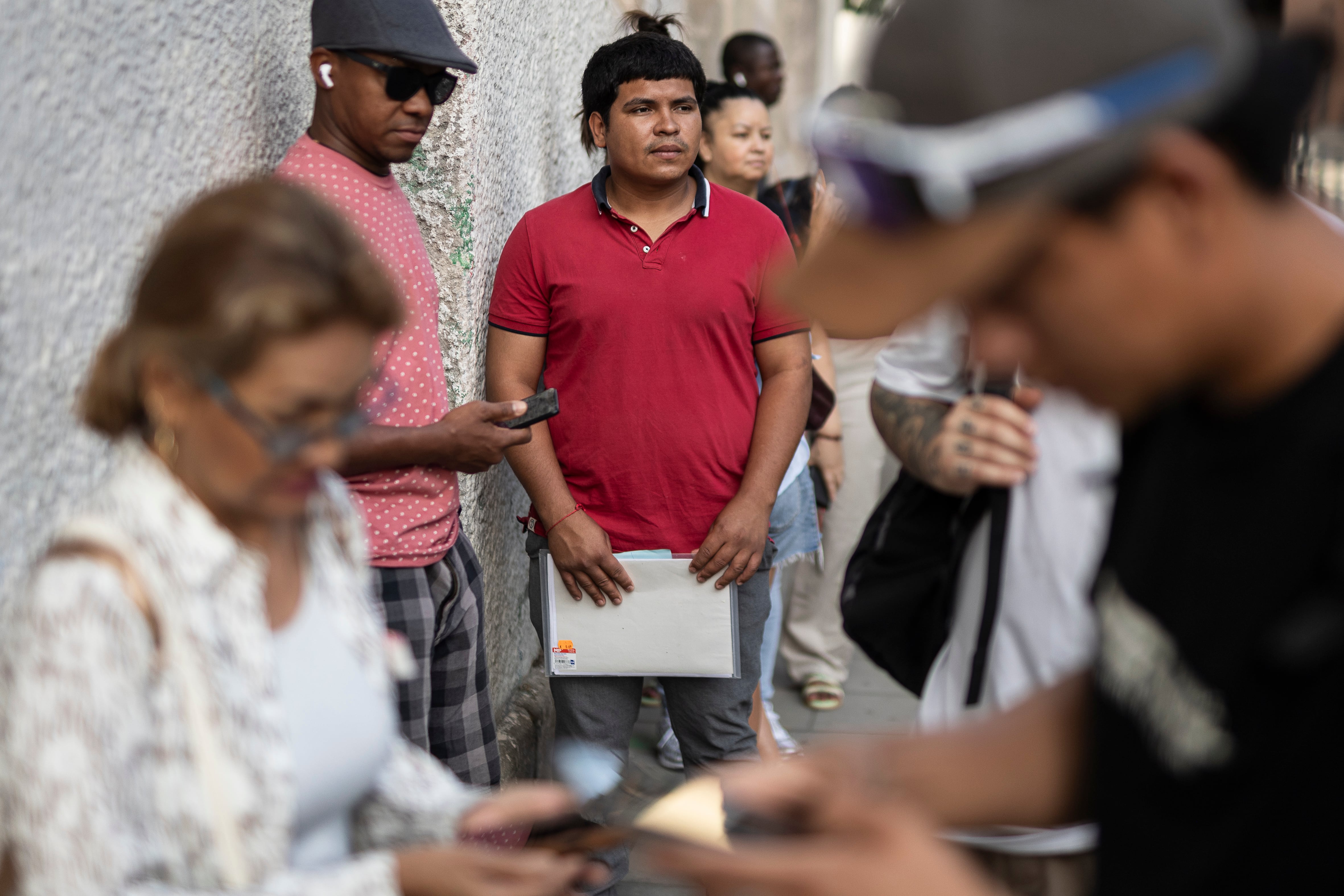 Colas para la regularización de migrantes en la oficinas del centro integral de apoyo a la regularización Miquel Bleach del Ayuntamiento de Barcelona, este lunes.
