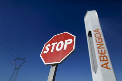 Señal de stop al lado de una torre de una planta de energía solar de Abengoa.