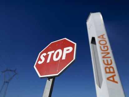 Señal de stop al lado de una torre de una planta de energía solar de Abengoa.