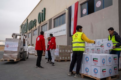 Miembros de la Media Luna Roja Egipcia preparan ayuda humanitaria para entrar en la franja de Gaza, este miércoles, en Rafah (Egipto). 