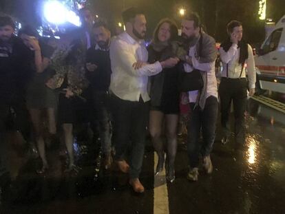 Un grupo de jóvenes abandonan la discoteca después del ataque.