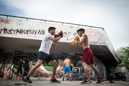 Una de las sesiones de kung-fu en un rincón retirado del céntrico parque dedicado a Ares en Atenas. A la izquierda, Ehsan Ahmadi, un refugiado afgano profesor de la ONG. A la derecha, Aresh, un afgano de 17 años que lleva cinco Grecia esperando para reunirse con su familia en Alemania.