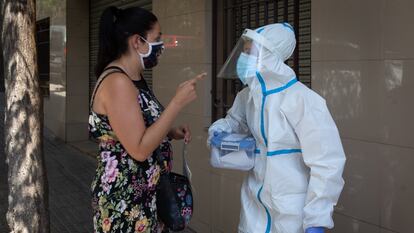 A woman speaks with a health worker in Ripollet, in Barcelona province, where the Catalan region government has begun a mass Covi-19 testing campaign.