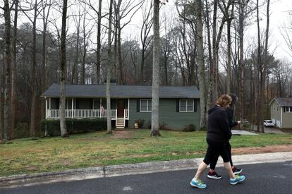 Dos personas pasan frente a la casa de Robert Aaron Long en Creek Hollow, Woodstock cerca de Atlanta, Georgia, este miércoles. Long es sospechoso por los tiroteos a los tres centros de masaje.