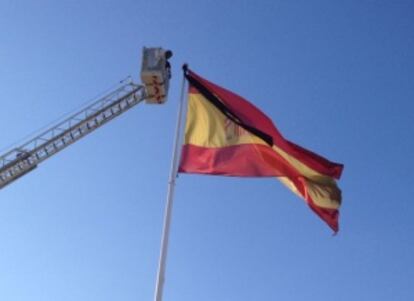 Los bomberos colocan un crespón negro en la bandera que hay a la entrada del municipio en señal de duelo.