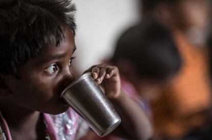 Un niño bebe agua mientras come en Surguja, India. Está en un centro de día infantil que lucha contra la malnutrición en menores de entre seis y 36 meses en la región de Chhattisgarh.