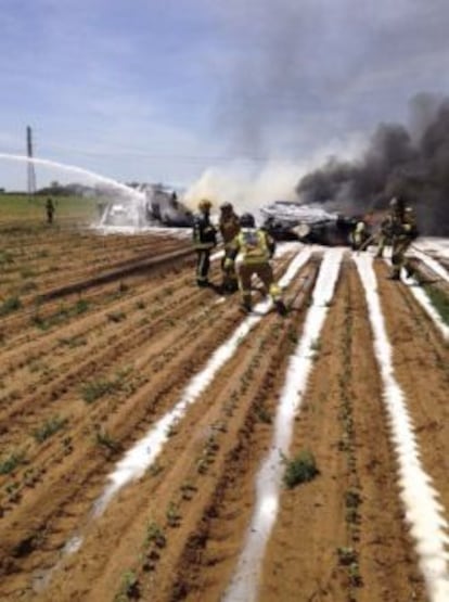 Bomberos extinguiendo el incendio provocado por el accidente del avión militar en los alrededores de Sevilla.