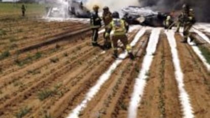 Bomberos extinguiendo el incendio provocado por el accidente del avión militar en los alrededores de Sevilla.