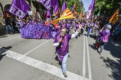 Una mujer ondea una bandera en la marcha del 1 de Mayo durante el transcurso de la manifestación por el centro de Girona.