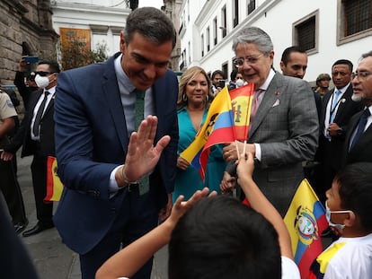 El presidente del Gobierno de España, Pedro Sánchez, y el presidente de Ecuador, Guillermo Lasso (a la derecha), saludan a unos niños durante un breve recorrido a pie desde el Palacio de Carondelet hasta la Iglesia de la Compañía de Jesús, en Quito (Ecuador).