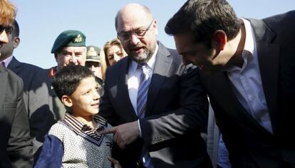 El primer ministro griego, Alexis Tsipras, y el presidente del Parlamento europeo, Martin Schulz, con un joven migrante en Lesbos, el 5 de noviembre de 2015.