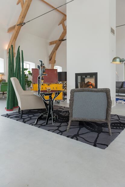 Junto a la chimenea, el biombo Grass (hierba) es de otro creador holandés, Anthony Kleinepier. La butaca gris es el modelo Clay Chair de un amigo de la pareja, el diseñador Maarten Baas. La mesa es de la colección Protopunk de Van Bleiswijk.