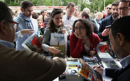 Una lectora mira con admiración a uno de los escritores que se han dado cita en la Feria del libro de Madrid.