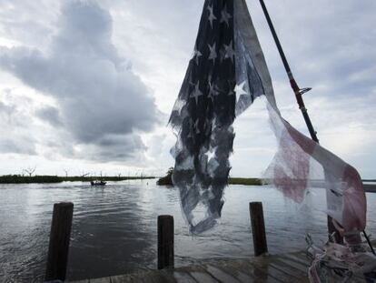 Una bandera rasgada de EE UU colgaba ayer de un mástil cerca de la isla de Jean Charles, en Luisiana.