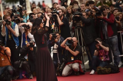 La actriz italiana Monica Bellucci, saluda a sus fans frente a la prensa mientras camina por la alfombra roja del 64 Festival de Cine de San Sebastián.