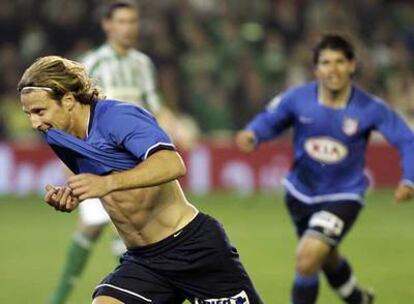 Forlán celebra su gol perseguido por Agüero.