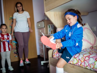 Candela Caballero se pone las zapatillas de deporte en su dormitorio junto a su madre y su hermana.