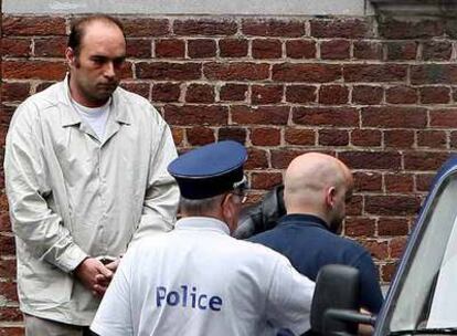 La policía escolta a Didier Charron (izquierda) cuando abandona ayer los juzgados de Verviers (Bélgica).