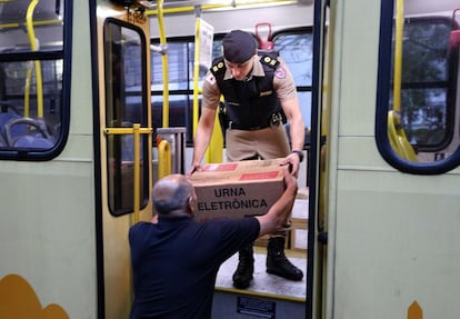 Um policial entrega uma urna eletrônica em em um colégio eleitoral de Belo Horizonte.