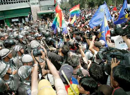 Seguidores del presidente Rafael Correa y agentes de la policía, ayer en los accesos del Parlamento de Ecuador, en Quito.