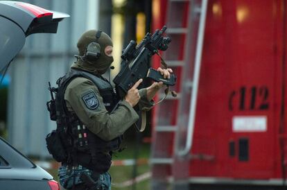 Un francotirador de las fuerzas especiales, coloca el cargador de su arma reglamentaria y toma posiciones en el entorno del centro comercial.