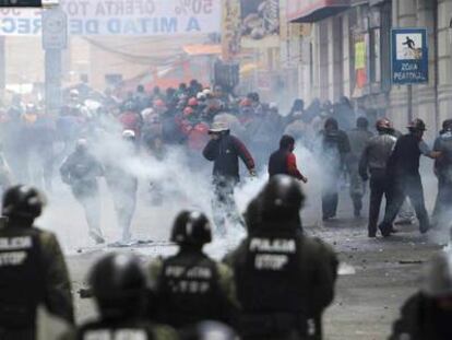 Manifestantes contra el Gobierno boliviano retroceden ante los gases lacrimógenos lanzados por la policía en La Paz.