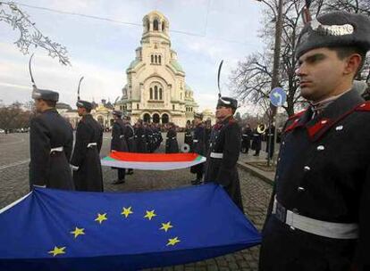 Soldados rumanos sostienen en primer plano la bandera de la UE en una ceremonia el martes en Sofía.