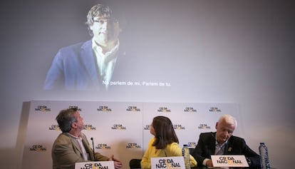 Los diputados Antoni Morra y Gemma Geis y el delegado Ferran Mascarell y en la pantalla, el expresidente Puigdemont.