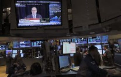 Operadores de la Bolsa de Nueva York con Ben Bernanke en la televisi&oacute;n