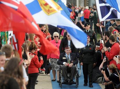 El p&uacute;blico aplaude al paso de un veterano canadiense en Courseulles-sur-Mer, Normand&iacute;a. 