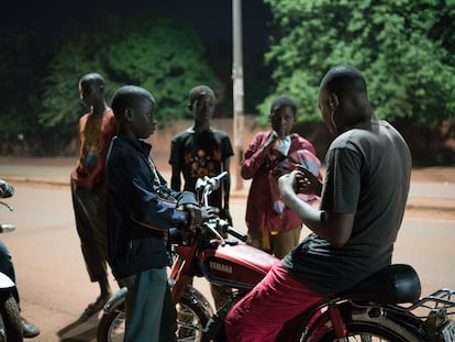 Theophile Palenfo, educador social, habla con un grupo de niños que se ha encontrado en la calle durante la vuelta de reconocimiento que hace tres días a la semana para identificar los niños en situación de calle en la ciudad de Bobo-Dioulasso, en Burkina Faso.