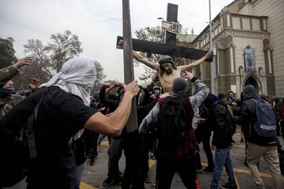 Un grupo de encapuchados sacan el Cristo de la iglesia. 