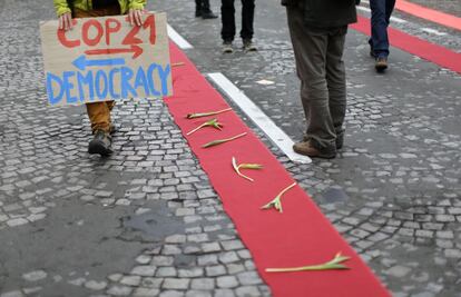 El prefecto de Policía de París, Michel Cadot, recordó que las manifestaciones están prohibidas por el estado de emergencia, pero reconoció que tres de ellas serían toleradas, aunque anunció el despliegue de unos 2.000 agentes para evitar actos violentos como los que tuvieron lugar hace dos semanas con motivo de la apertura de la COP21. En la imagen, un activista climático sostiene una pancarta durante una manifestación.
