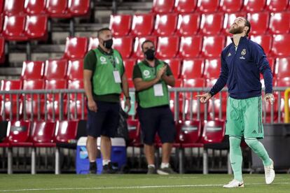 Sergio Ramos pisa el campo del Granada CF para entrar en calor el pasado lunes. Detrás, dos trabajadores del club con mascarilla. 