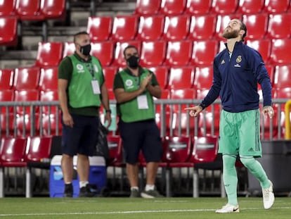 Sergio Ramos pisa el campo del Granada CF para entrar en calor el pasado lunes. Detrás, dos trabajadores del club con mascarilla. 