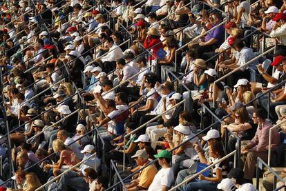 El público se protege del sol durante el encuentro.