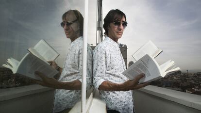 El escritor y periodista lee un libro en la terraza de la cadena Ser, en Madrid.