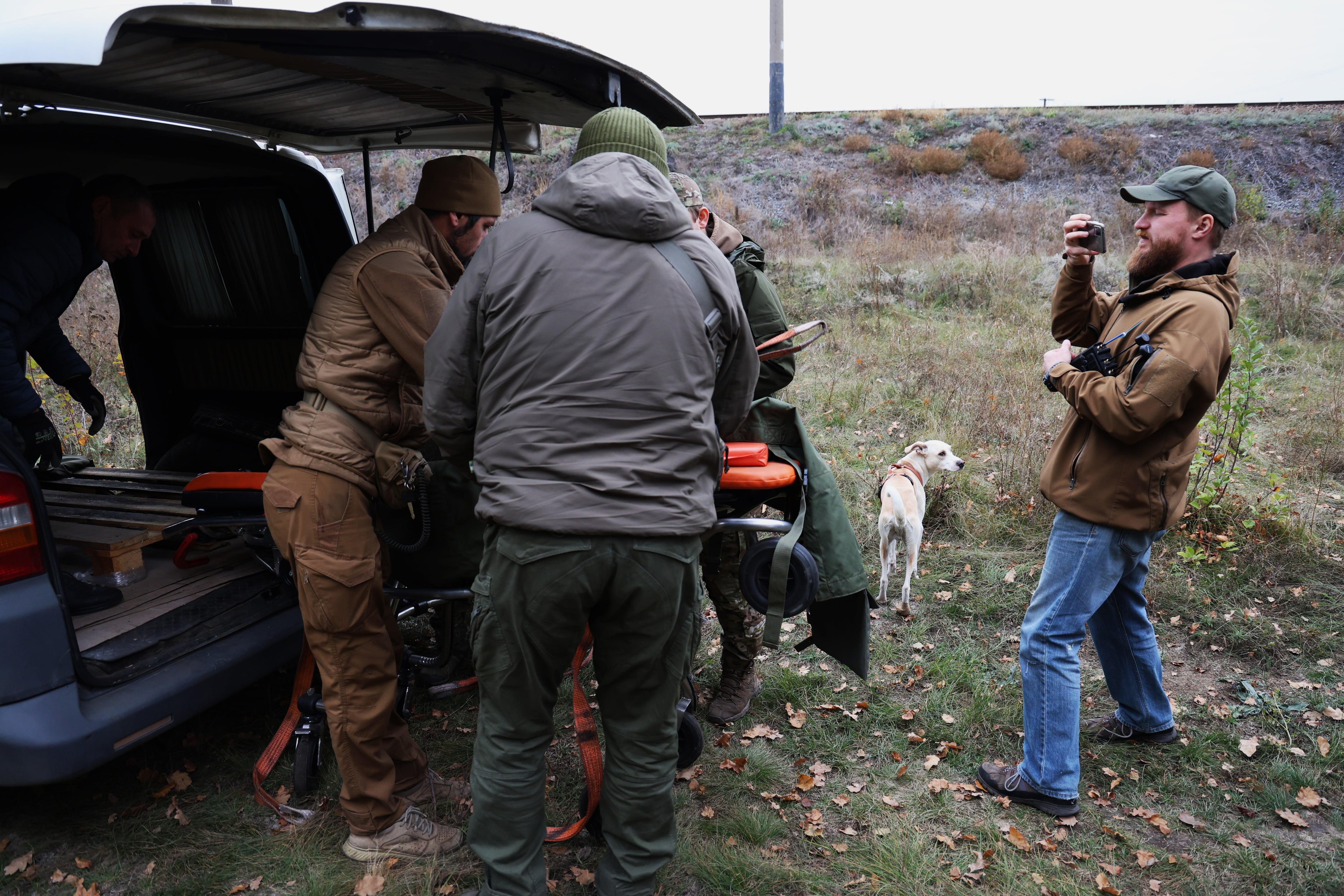 El historiador Yurii Fanihin (derecha) documenta con su móvil el traslado de la imagen de un guerrero de piedra de 900 años.