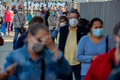 People wait in line for a rapid coronavirus antigen test in the Madrid neighbourhood of Vallecas.