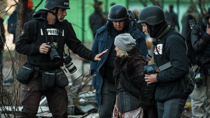 Varios periodistas hablan con una mujer, unos días después de la invasión rusa de Ucrania, en 2022.