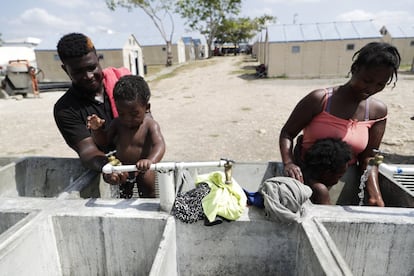 Dos mujeres haitianas migrantes bañan a sus bebés en el centro de acogida de San Vicente, en la provincia de Darien, en Panamá, el 9 de febrero de 2021. Panamá está admitiendo a miles de migrantes que no pueden acceder a Costa Rica por las restricciones de la pandemia. Entre las causas por las que miles de niños haitianos cruzan la frontera de su país, la menos mala es que vayan acompañando a sus familiares.