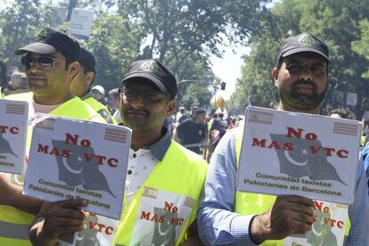 Tres manifestantes pakistaníes sujetan pancartas contra los VTC en la huelga de taxistas de Madrid.